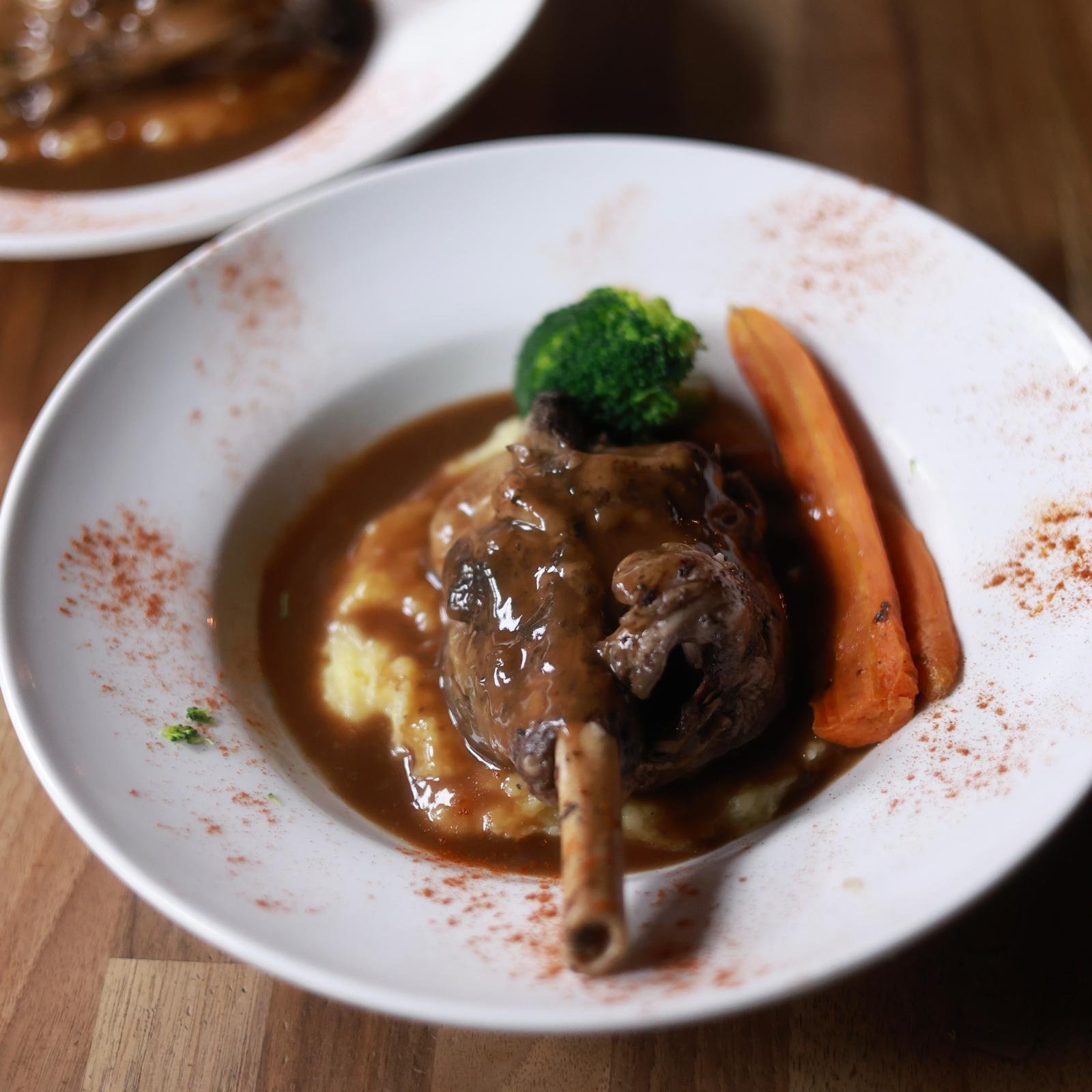 Slow-cooked lamb shank on the bone with mashed potato, rosemary gravy, broccoli and carrots